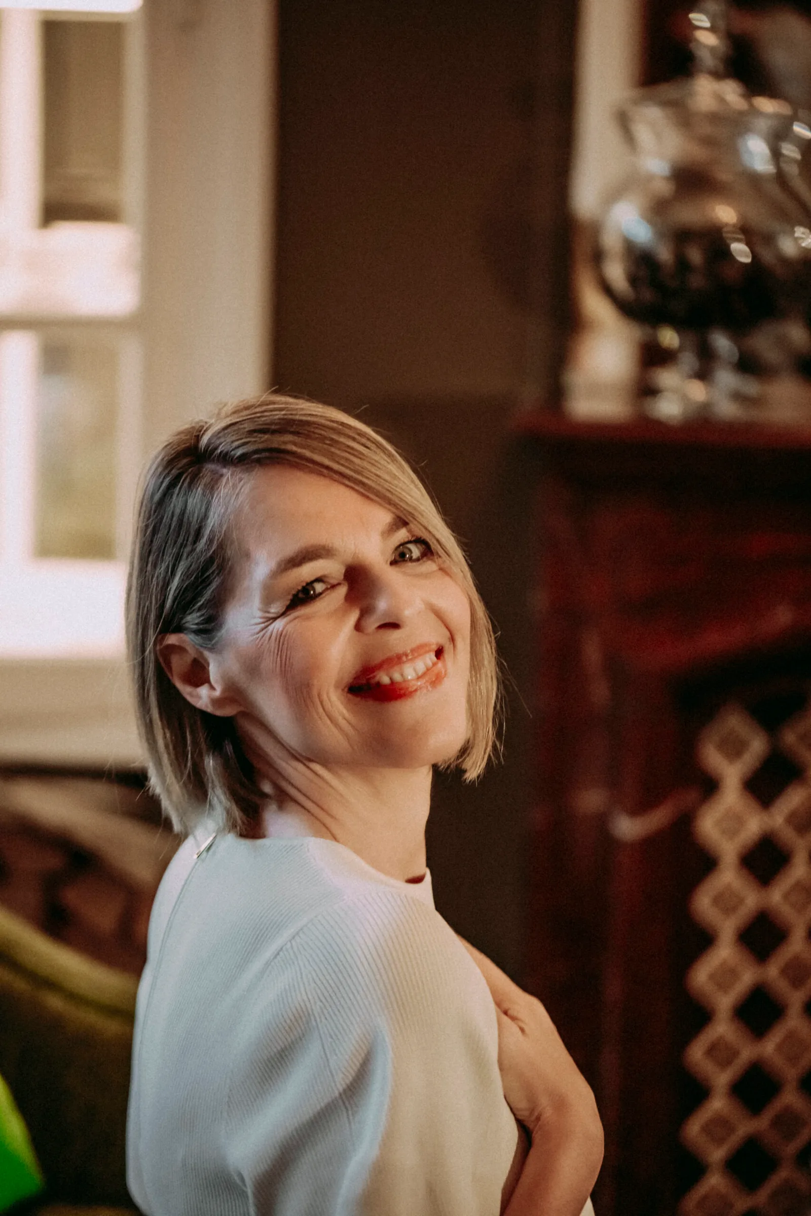 Porträt Katja Hinterleitner in Innenraum, lächelnd zur Seite, Nahaufnahme