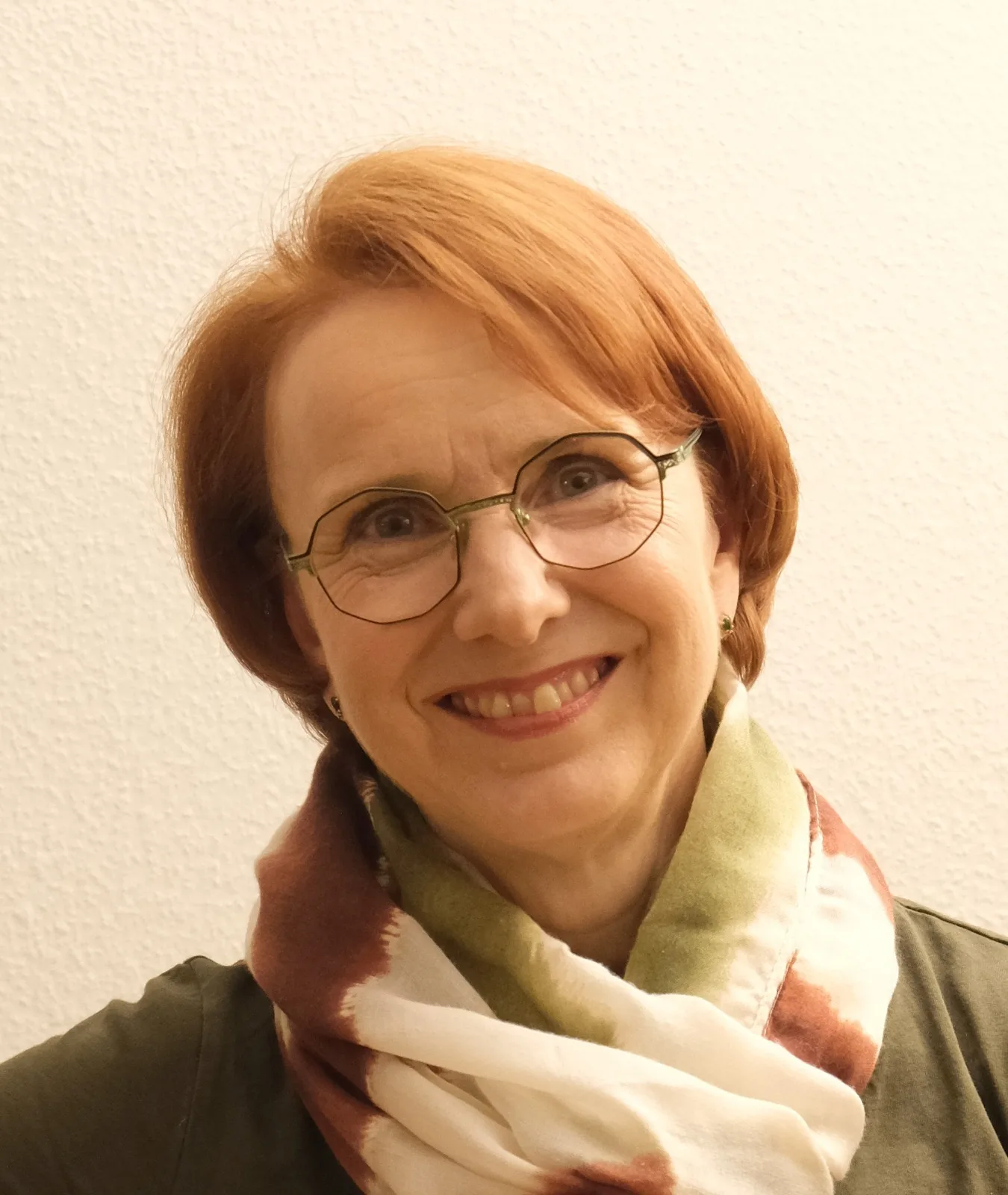Gina Heller, TCM-Naturärztin und Schlaf-Coach, Porträt mit Brille und buntem Schal