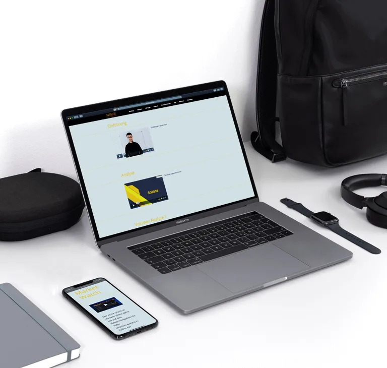 Laptop und Smartphone zeigen Video-Coaching Portal mit Serdar Karaca und gelben Lernmodulen