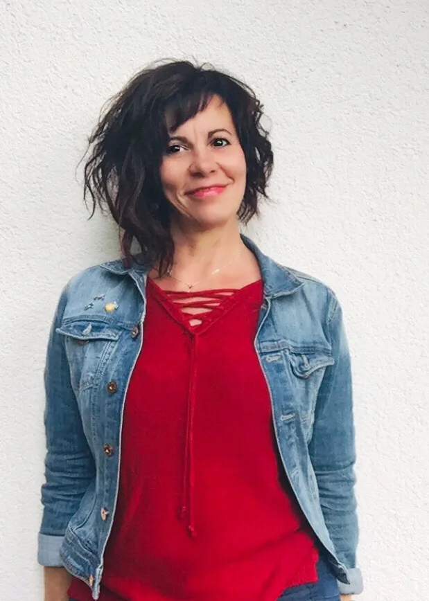 Porträt von Iris Arimond in rotem Spitzentop und Jeansjacke