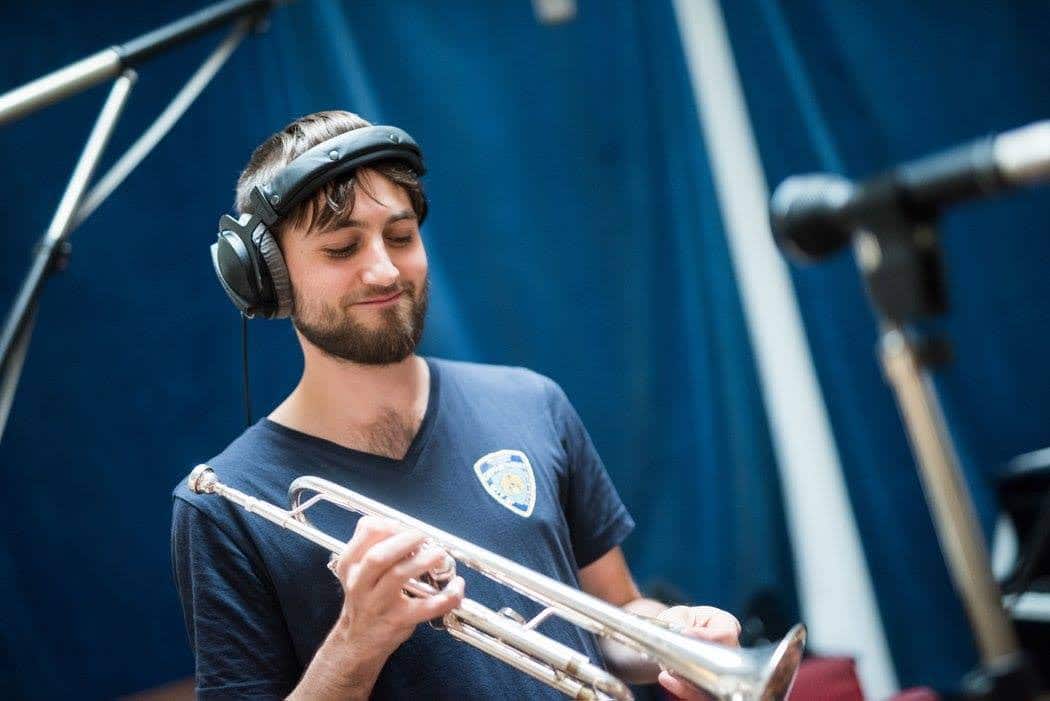Trompete lernen – Komplettkurs von Tobi Till Krüger 3 Tobi Till Krüger mit Kopfhörern und Trompete im Aufnahmestudio vor blauem Hintergrund