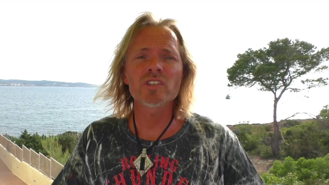 TUN – Videokurs gegen Aufschieben von Siranus Sven von Staden 3 Siranus von Staden mit langen Haaren am Meer mit Baum und Küstenlandschaft im Hintergrund