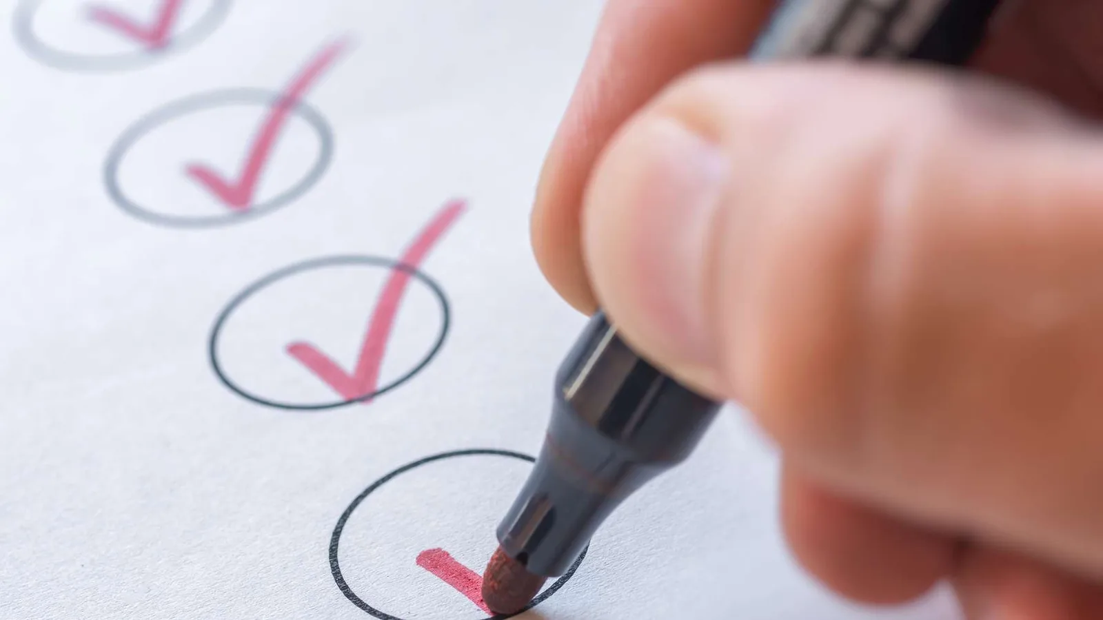 TUN – Videokurs gegen Aufschieben von Siranus Sven von Staden 1 Hand mit Stift setzt Häkchen auf Checkliste mit mehreren angekreuzten Kästchen