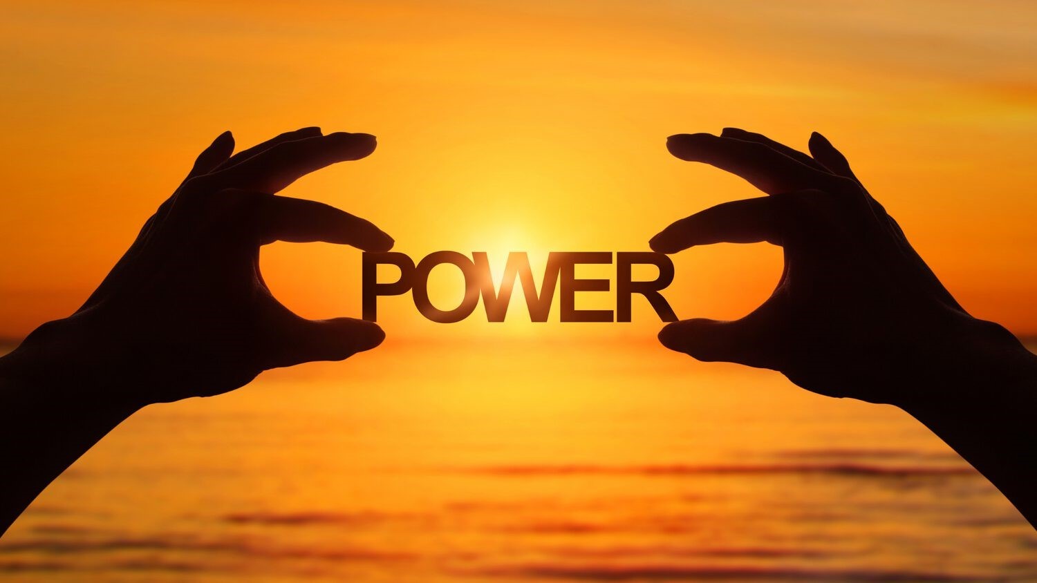 Silhouetten von zwei Händen halten das Wort POWER gegen orangegold leuchtenden Sonnenuntergrund