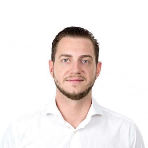 Porträtfoto von René Renk, Mann mit dunklem Haar in weißem Hemd vor hellem Hintergrund