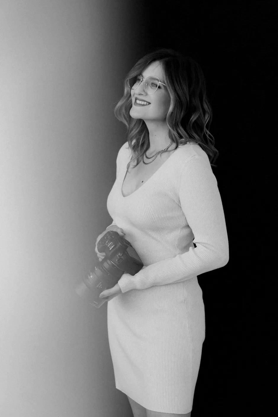 Schwarz-Weiß Portrait von Luisa Mähringer, Fotografin und Mentorin, mit Kamera