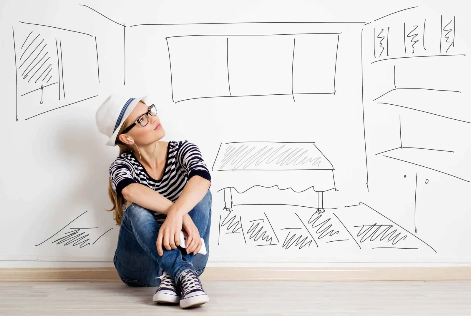VIP-Premium-Workshop – Feng-Shui-Videokurs mit Materialien 4 Frau sitzt vor Raumskizze an Wand mit Hut und Brille, plant Innenraumgestaltung