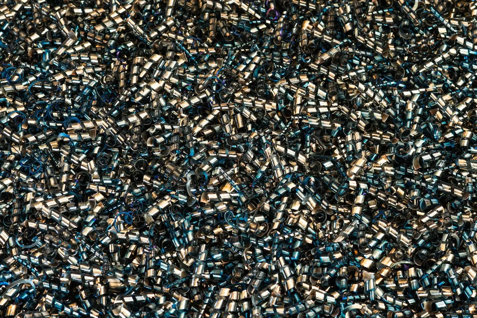 Nahaufnahme von metallischen Buchsen in Blau und Silber, chaotisch durcheinander liegende elektronische Komponenten