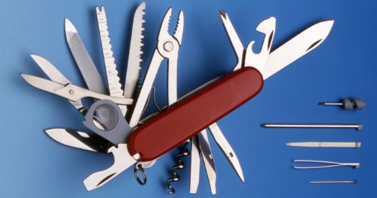 Schweizer Taschenmesser mit ausgefahrenen Werkzeugen auf blauem Hintergrund
