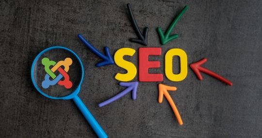 Joomla-Logo mit bunten Pfeilen und großem SEO-Schriftzug auf grauem Untergrund