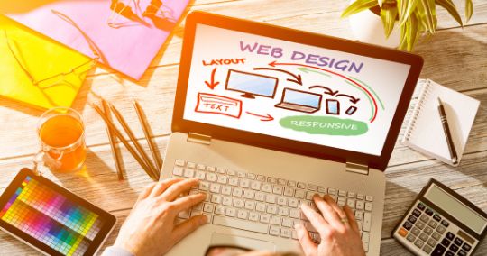 Laptop-Bildschirm zeigt Webdesign-Sketch mit Hand auf Tastatur und Farbpalette