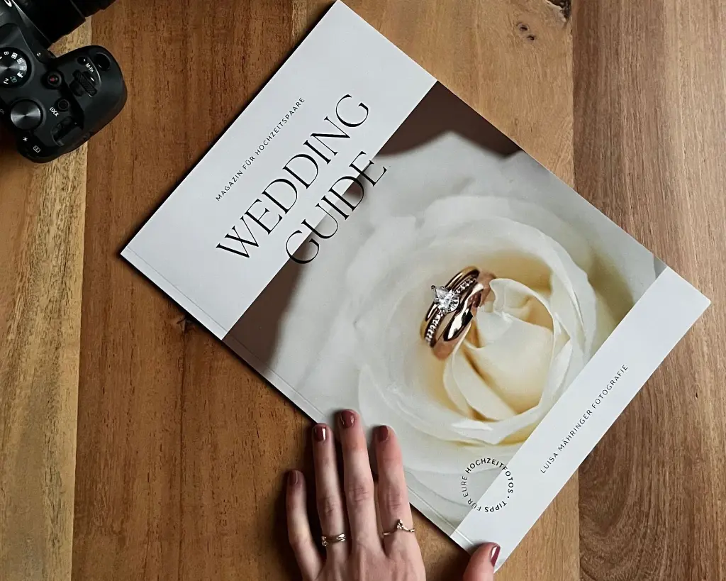 Wedding Guide Magazin Cover mit Ehering auf weißer Rose, Kamera und Hand mit Ring auf Holztisch