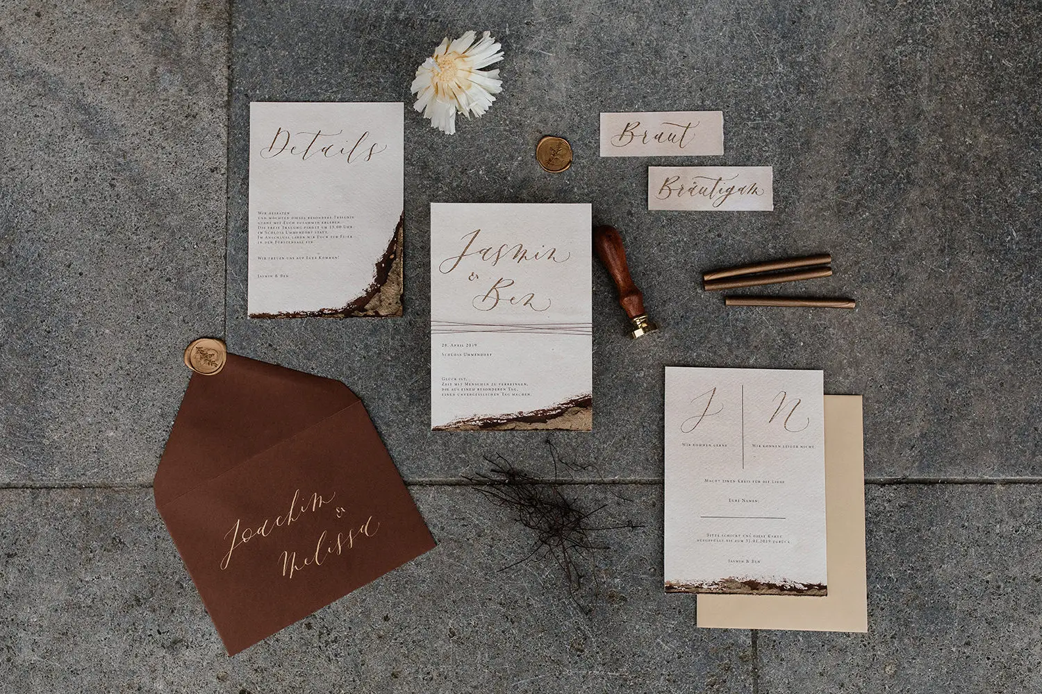 Flatlay mit Hochzeitspapereterie auf Betonuntergrund mit Namen Jasmin & Ben, Details, Braut und Bräutigam