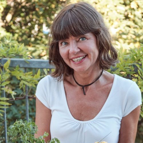 Sandra Fleckenstein lächelnd im Grünen, Porträtfoto mit Halskette