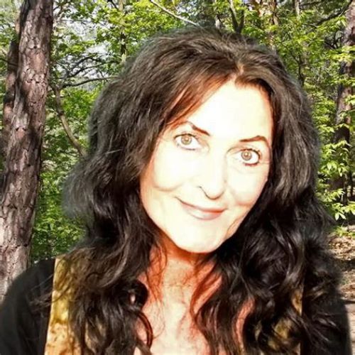 Junge Frau mit langen dunklen Haaren vor hellblauem Hintergrund
