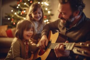 becomePro 11 Familie sitzt vor Weihnachtsbaum, Vater spielt Gitarre für zwei Kinder