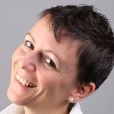 Wie geht Selbstliebe? – Videokongress zur Selbstliebe 7 Porträt Anita Zoder, Frau mit dunklen Haaren und weißem Oberteil, lächelnd