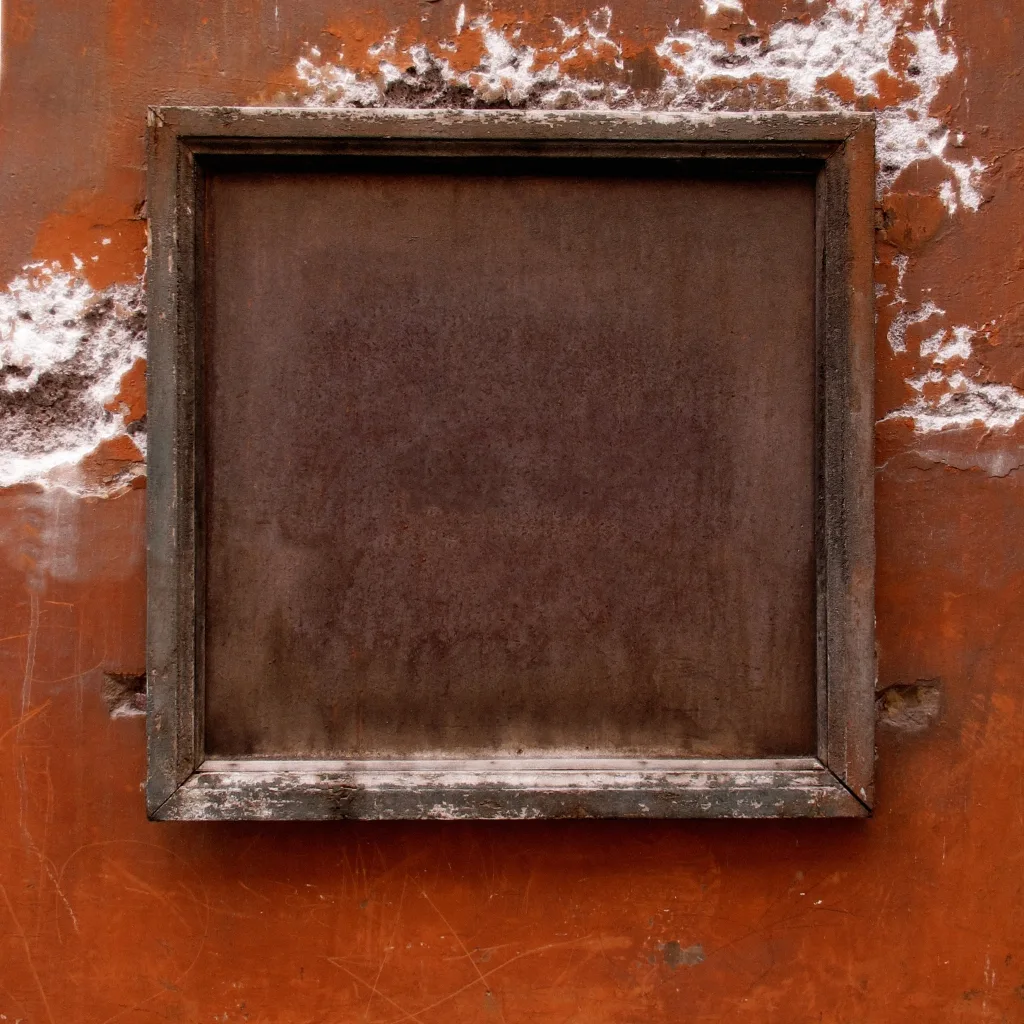Leeres Fenster mit braunem Rahmen auf verwitterter terrakottafarbener Wand