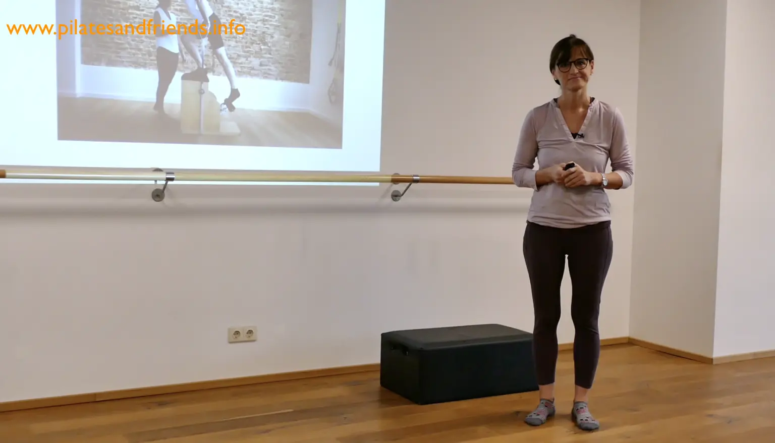 Martina Heuel präsentiert Pilates-Workshop vor Beamer