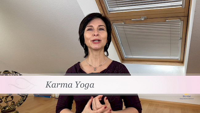 Nicole Blümlinger sprechend vor Schreibtisch, braunes Oberteil, Untertitel 'Karma Yoga' sichtbar