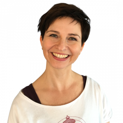 Porträt Nicole Blümlinger in weißem T-Shirt, kurze dunkle Haare, lächelnd, quadratisches Zuschnitt