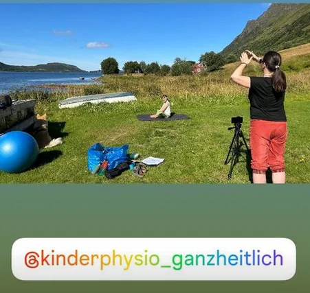 Outdoor-Trainingsszene mit Kinderphysiotherapeutin an einem See, Kind trainiert auf Wiese mit Trainerin, Kamera und Trainings