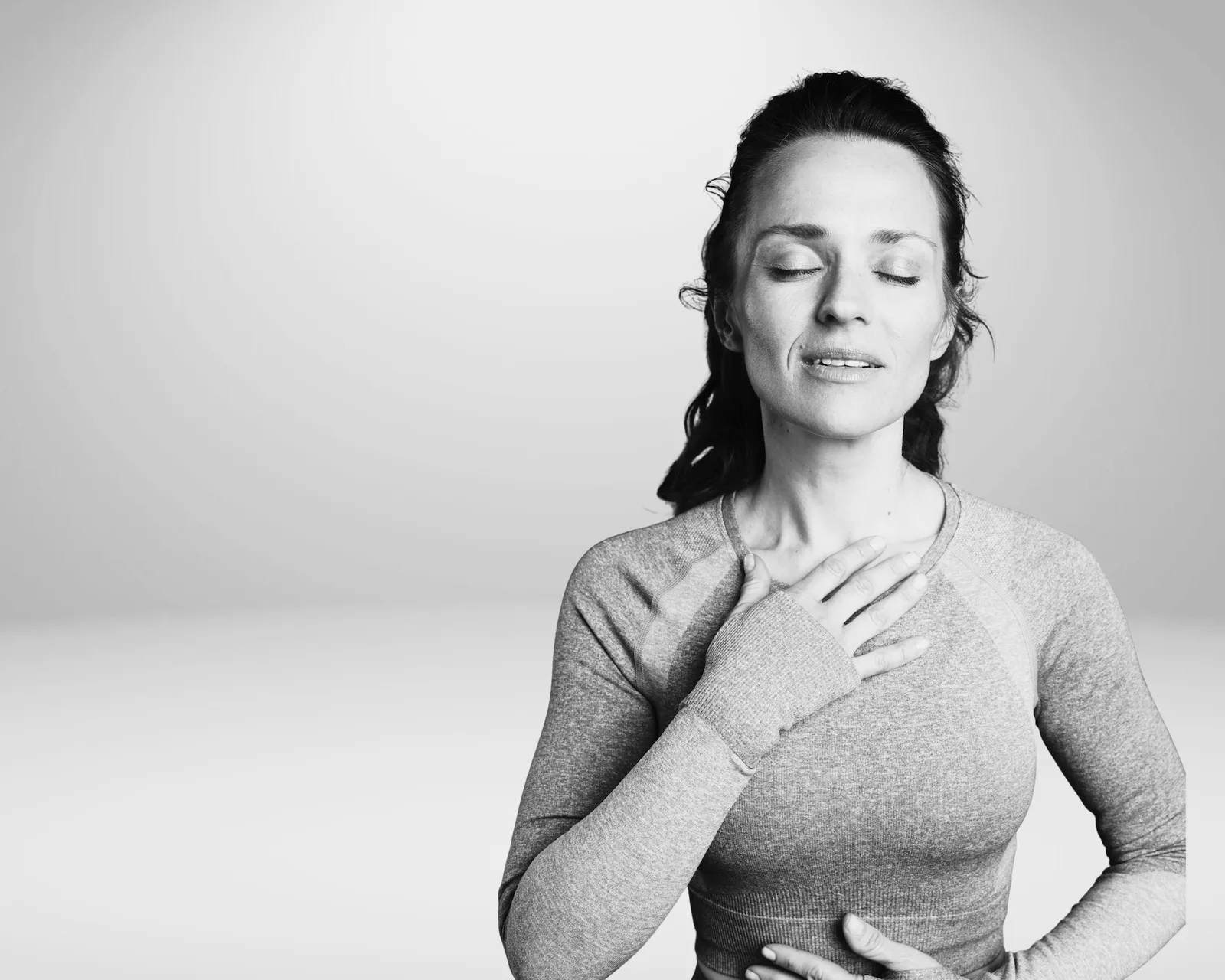 Frau mit geschlossenen Augen und Hand auf Brust in entspannter, meditativer Haltung