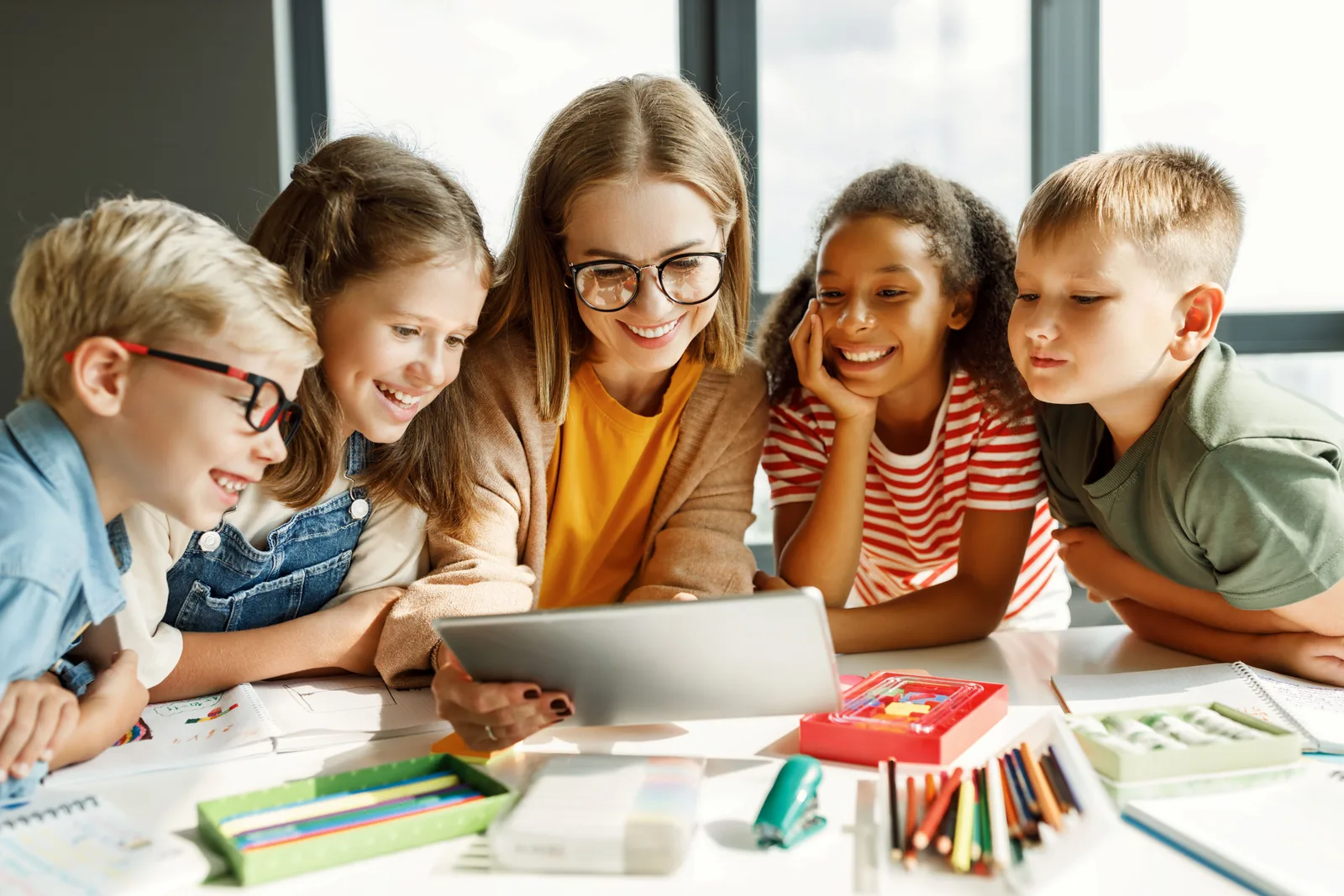 Lehrerin lächelt in Klassenzimmer, unterrichtet interkulturell
