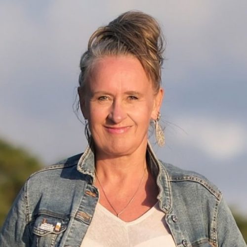 Porträt von Brigitte Burstedde, Frau mit hochgestecktem braunem Haar, Jeansjacke und weißem Shirt